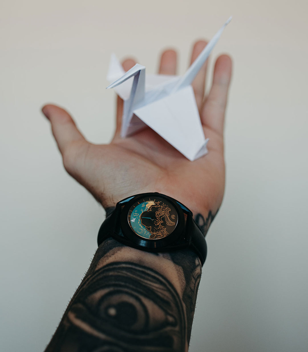 Paper Crane watch on wrist holding paper crane