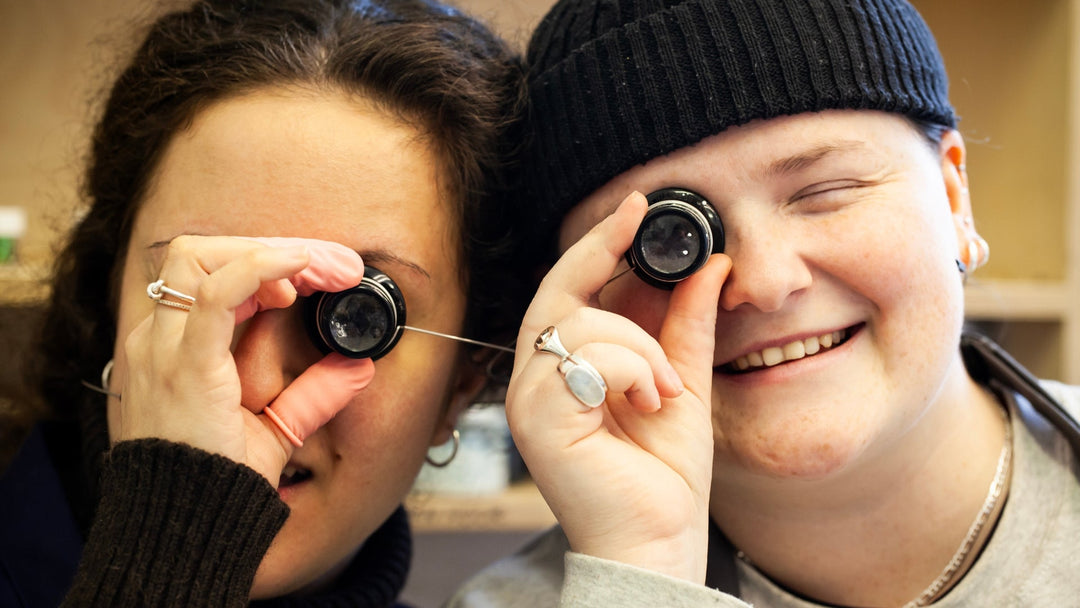 Workshop technicians holding magnifying glasses to their eyes
